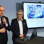 Przy stoliku z laptopem na stojąco wicemarszałek Województwa Śląskiego Leszek Pietraszek przemawiający do mikrofonu, obok niego dyrektor KCO – Włodzimierz Migacz, w tle prezentacja o operacjach wykonywanych przez robota.