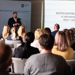 Prelegent przy mównicy oraz uczestnicy spotkania na sali